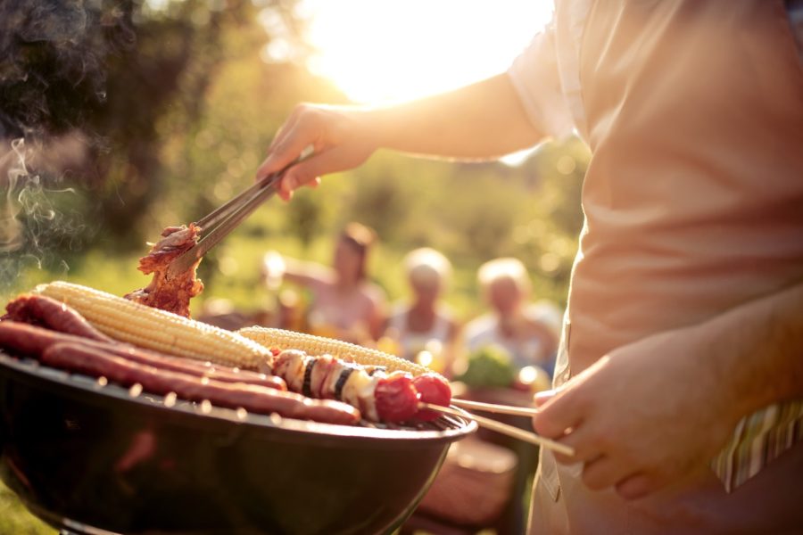 Close-up of meat cooking on a garden grill during a summer barbecue party, illustrating common food scraps handled by Putman and Sons Plumbing.