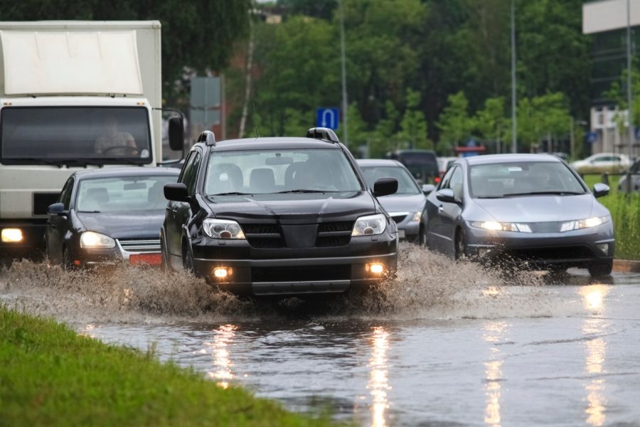 Flooded road and heavy storm runoff, highlighting when to call Putman & Son’s Plumbing for emergency sewer line drainage issues.