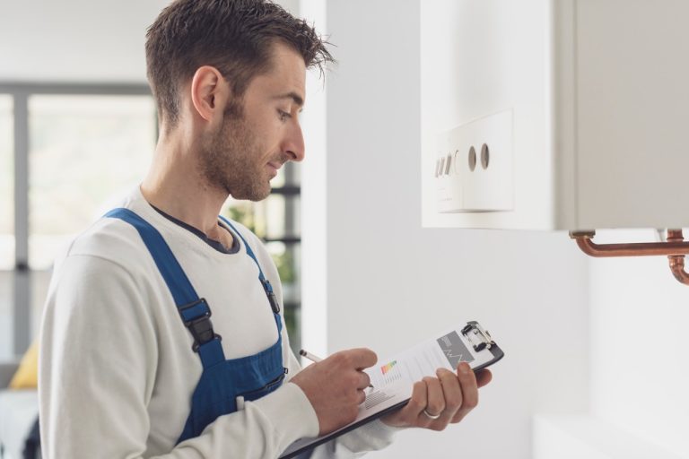 Plumbing technician inspecting home water heater and piping systems to prevent unexpected leaks.