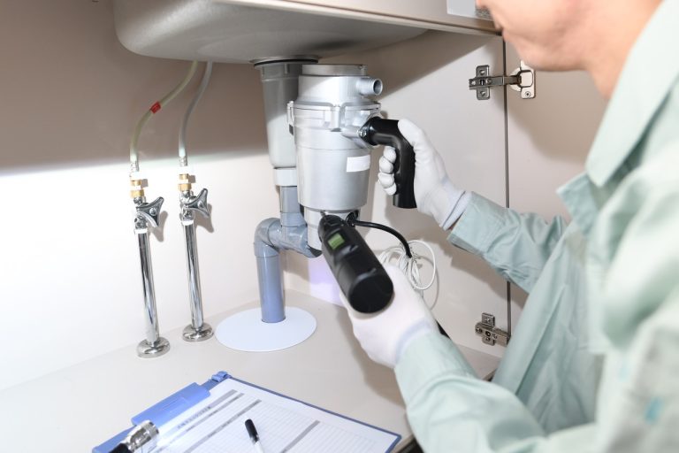 Professional kitchen plumbing maintenance on a garbage disposal unit by the team at Putman and Sons Plumbing.