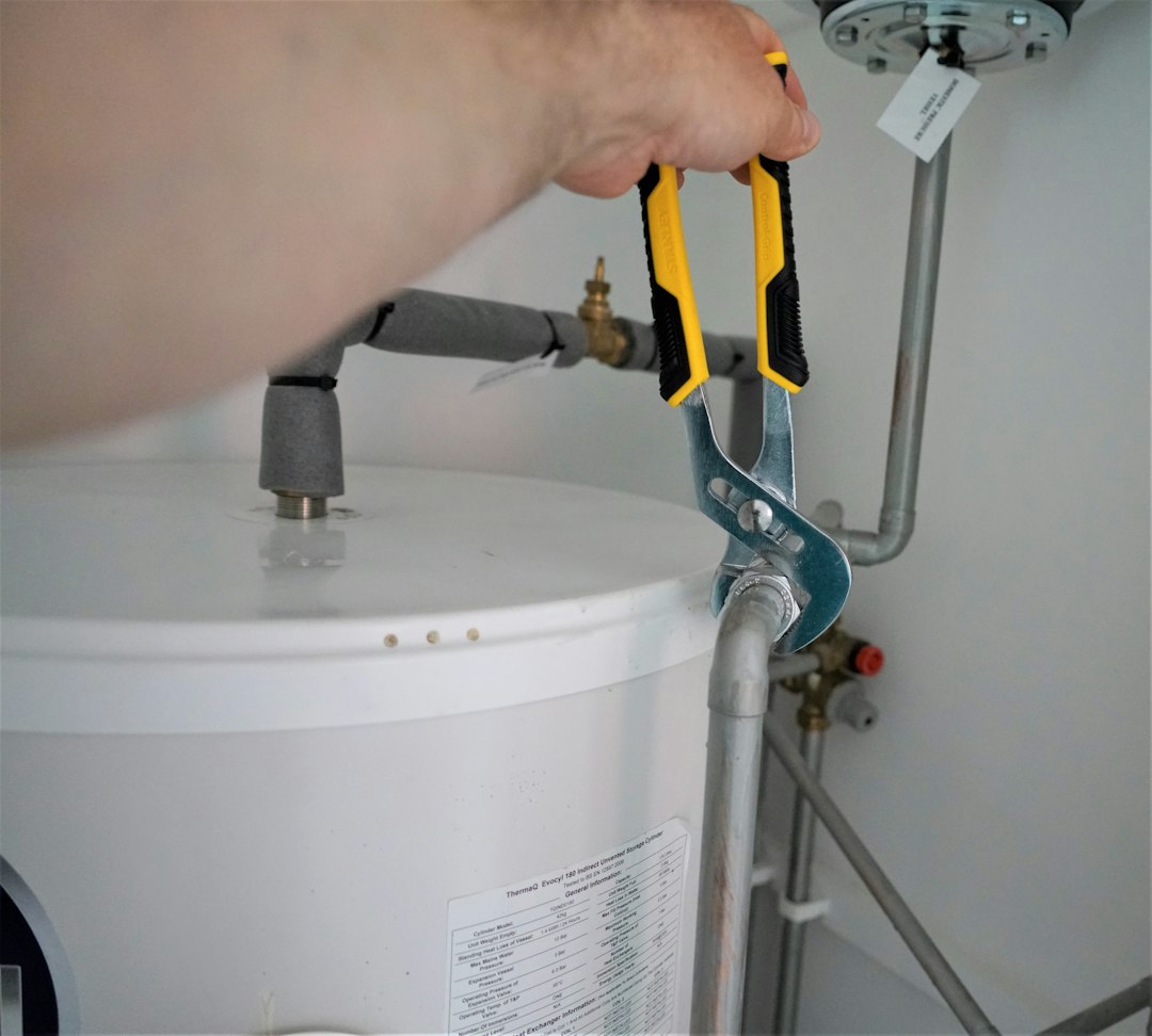 Plumbing technician using tools during a water heater installation